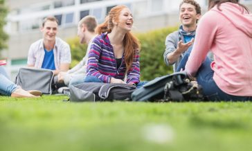Group of young college students sitting in the park